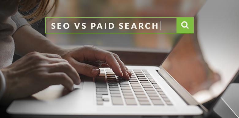 Person on laptop typing SEO vs. paid search