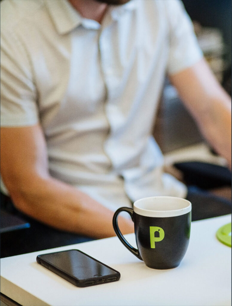 Man sitting at desk with cup of coffee