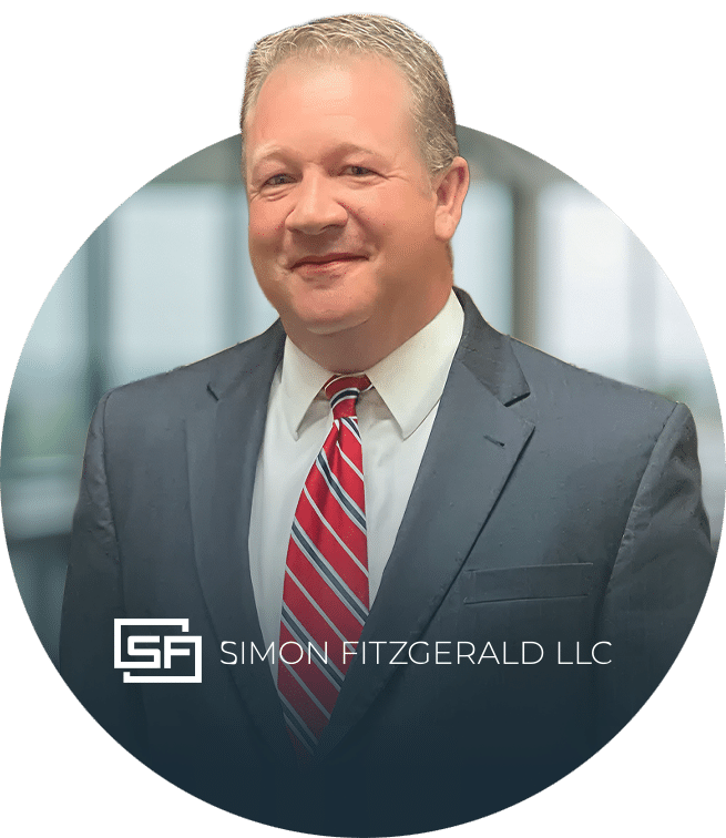 A man in a suit and red striped tie smiles in front of a blurred office background. The Simon Fitzgerald LLC logo is displayed at the bottom center of the image.